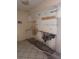 Damaged kitchen features missing cabinets, tile flooring, and exposed wall damage at 4215 E Bay Dr # 1701B, Clearwater, FL 33764
