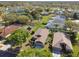 Aerial view of the community showcasing well-maintained homes, mature trees, and a serene pond at 4410 Sawgrass Dr, Palm Harbor, FL 34685