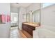Bright bathroom features a dual sink vanity, a soaking tub, and a view into the bedroom at 4410 Sawgrass Dr, Palm Harbor, FL 34685