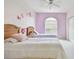 Bright bedroom featuring twin beds, an arched window, and playful butterfly accents on the lavender and white walls at 4410 Sawgrass Dr, Palm Harbor, FL 34685
