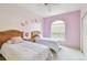 Cozy bedroom with two twin beds, pastel colors, and a sunny window at 4410 Sawgrass Dr, Palm Harbor, FL 34685