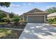 Charming one-story home featuring a well-manicured lawn and two-car garage at 4410 Sawgrass Dr, Palm Harbor, FL 34685