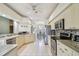 Spacious kitchen with stainless steel appliances, white cabinetry, and a view of the dining area at 4410 Sawgrass Dr, Palm Harbor, FL 34685