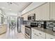 Bright kitchen with stainless steel appliances, tile backsplash, and view to the dining area at 4410 Sawgrass Dr, Palm Harbor, FL 34685