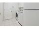 Cozy laundry room featuring a modern washer and dryer, tiled floor and a white door at 4410 Sawgrass Dr, Palm Harbor, FL 34685