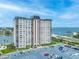 Exterior view of a high-rise condominium featuring a large parking lot and waterfront access at 5220 Brittany S Dr # 1409, St Petersburg, FL 33715
