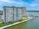 Exterior view of a high-rise waterfront condominium featuring a pool and dock at 5220 Brittany S Dr # 1409, St Petersburg, FL 33715