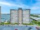 Exterior view of a high-rise condominium featuring a large parking lot and waterfront access at 5220 Brittany S Dr # 1409, St Petersburg, FL 33715