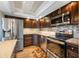 Modern kitchen featuring stainless steel appliances, dark cabinets, and tile backsplash at 5220 Brittany S Dr # 1409, St Petersburg, FL 33715