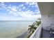 Expansive balcony view showcasing the waterfront, clear skies, and tropical palm trees at 5279 Isla Key S Blvd # 313, St Petersburg, FL 33715
