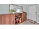 Close-up view of a wooden cabinet with a gold mirror in a neutrally painted living room at 536 63Rd S Ave, St Petersburg, FL 33705