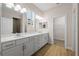 Bright bathroom with double vanity, ample lighting, and wood-look tile floors at 5807 Silver Sun Dr, Apollo Beach, FL 33572