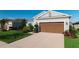Well-maintained home showcasing a lush green lawn and a brown two-car garage at 5807 Silver Sun Dr, Apollo Beach, FL 33572