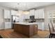Modern kitchen with stainless steel appliances, white cabinets, and an island with a white countertop at 5807 Silver Sun Dr, Apollo Beach, FL 33572