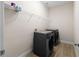 Convenient laundry room featuring modern washer and dryer, complemented by stylish wood-look tile flooring at 5807 Silver Sun Dr, Apollo Beach, FL 33572