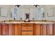 Dual sink bathroom vanity featuring granite countertops and wood cabinetry with large dressing mirror at 615 Islebay Dr, Apollo Beach, FL 33572