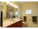 Well-lit bathroom featuring a large mirror, wooden vanity, neutral walls, and a shower with a tropical-themed curtain at 615 Islebay Dr, Apollo Beach, FL 33572