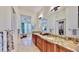 Bright bathroom showcasing double granite vanity with and sinks and walk-in closet access at 615 Islebay Dr, Apollo Beach, FL 33572