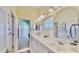 Bright bathroom featuring a double vanity, mirrors, and access to another room at 615 Islebay Dr, Apollo Beach, FL 33572