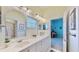 Bright bathroom featuring a double vanity, mirrors, and access to another room at 615 Islebay Dr, Apollo Beach, FL 33572