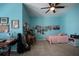 Bedroom with a bed, desk area and piano against blue walls, with a ceiling fan at 615 Islebay Dr, Apollo Beach, FL 33572