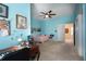 Bright bedroom with blue walls, a bed, ceiling fan, and an open doorway at 615 Islebay Dr, Apollo Beach, FL 33572
