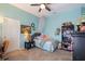 Cozy bedroom with bright walls, ceiling fan, study desk, and decorative bookcase at 615 Islebay Dr, Apollo Beach, FL 33572