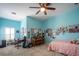 A vibrant bedroom with a ceiling fan, desk area, piano and eclectic decor against light blue walls at 615 Islebay Dr, Apollo Beach, FL 33572