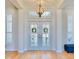 Bright foyer with double doors, shuttered windows, hardwood floors, and elegant lighting at 615 Islebay Dr, Apollo Beach, FL 33572