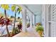 Inviting front porch with white columns, tile flooring, and lush tropical landscaping at 615 Islebay Dr, Apollo Beach, FL 33572