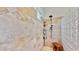 Walk-in travertine shower featuring built-in shelves, rainfall shower head, and glass block accent wall at 615 Islebay Dr, Apollo Beach, FL 33572