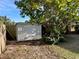 Backyard features a storage shed, a wood fence, and mature trees providing shade on a sunny day at 624 Folsom S St, St Petersburg, FL 33707