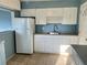 Kitchen with white appliances and cabinets paired with tile flooring at 624 Folsom S St, St Petersburg, FL 33707