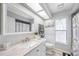 Bright bathroom features a window, granite vanity top, and shower-tub combo at 6242 Gainsboro Ave, Spring Hill, FL 34609