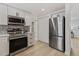 Modern kitchen featuring stainless steel appliances, quartz countertops, white cabinets, and a stainless steel refrigerator at 6921 Alken Cir, New Port Richey, FL 34653