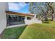 Exterior view of the home's backyard and screened patio area with mature trees at 7623 Radcliffe Cir # A101, Port Richey, FL 34668