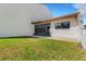 Exterior view of the home's backyard and screened patio area with green grass at 7623 Radcliffe Cir # A101, Port Richey, FL 34668