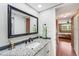 Bathroom featuring granite countertop, framed mirror, and doorway to bedroom at 7623 Radcliffe Cir # A101, Port Richey, FL 34668