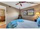 Cozy bedroom featuring ceiling fan, rocking chair, and adjacent walk-in closet and ensuite at 7623 Radcliffe Cir # A101, Port Richey, FL 34668