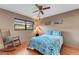 Bedroom with a rocking chair, ceiling fan, and bright patterned bedding at 7623 Radcliffe Cir # A101, Port Richey, FL 34668