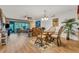 Bright dining and living area with wicker furniture, wood floors, and a sliding glass door to the patio at 7623 Radcliffe Cir # A101, Port Richey, FL 34668
