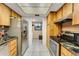Kitchen with wood cabinets, stainless steel appliances, and tile floors at 7623 Radcliffe Cir # A101, Port Richey, FL 34668