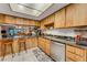 Kitchen featuring wood cabinets, stainless steel appliances, and bar-style seating at 7623 Radcliffe Cir # A101, Port Richey, FL 34668