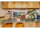 Open kitchen with granite countertops, wooden cabinets, and a view into the dining and living area at 7623 Radcliffe Cir # A101, Port Richey, FL 34668