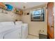 Laundry room with washer, dryer, storage shelves, and window at 7623 Radcliffe Cir # A101, Port Richey, FL 34668