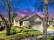 Well-kept single-Gathering home with a neat lawn and a two-car garage framed by large trees at 7853 Bristol Park Dr, Apollo Beach, FL 33572