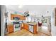 Bright kitchen showcasing stainless steel appliances, wood cabinets, and an open layout connected to the living room at 7853 Bristol Park Dr, Apollo Beach, FL 33572