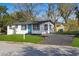 Charming one-story home featuring a bright turquoise door, manicured lawn, and newly paved driveway at 8501 N Alaska St, Tampa, FL 33604
