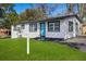 Charming home features a bright blue front door and freshly manicured lawn at 8501 N Alaska St, Tampa, FL 33604