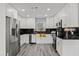Modern kitchen features white cabinetry, black countertops, and stainless steel appliances at 8501 N Alaska St, Tampa, FL 33604
